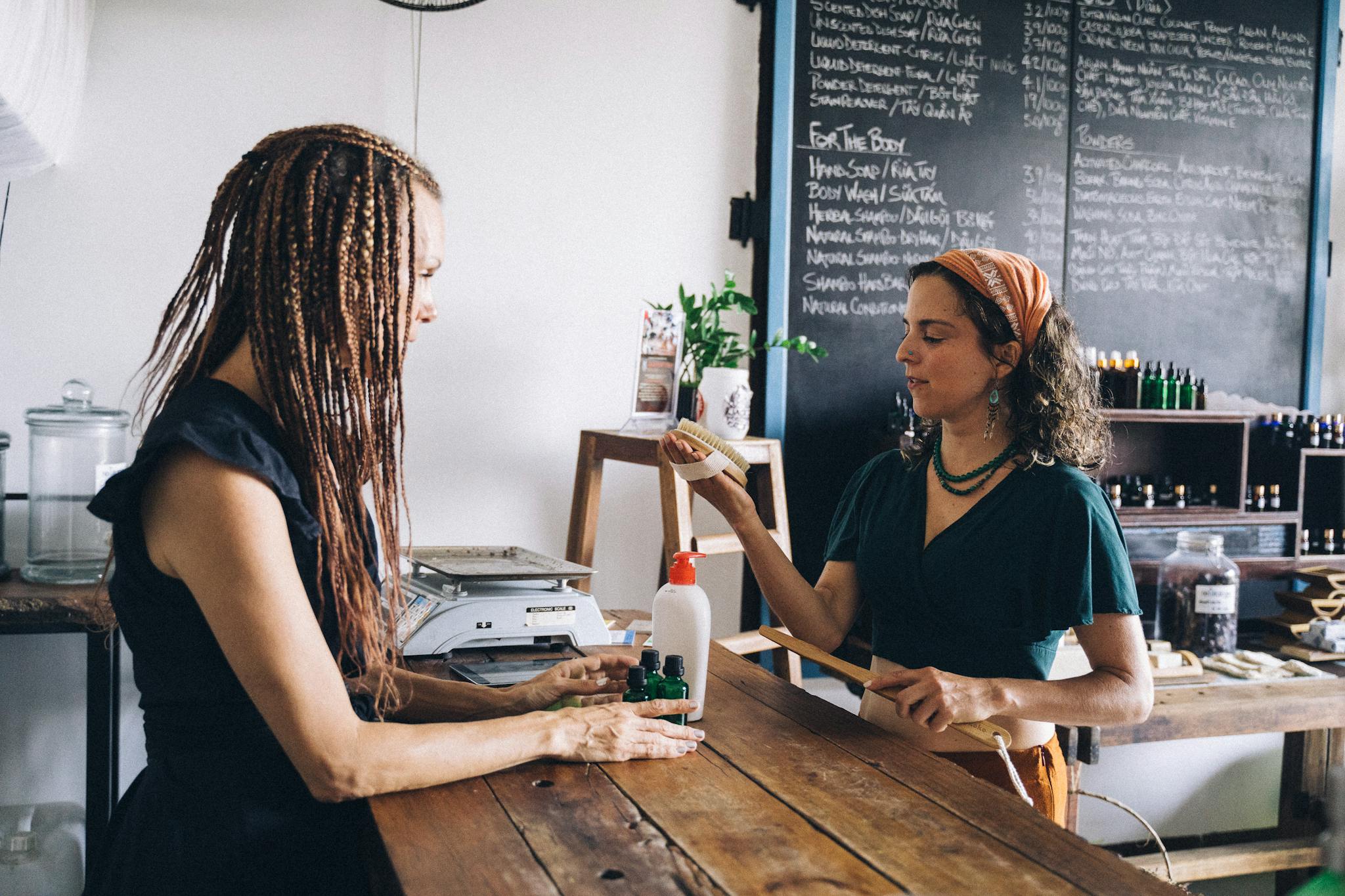 Two women interacting in an eco-friendly store, promoting organic products and sustainability.